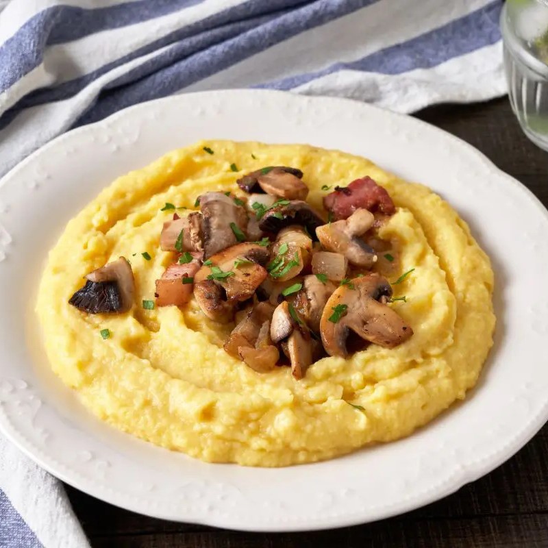 Plate of roasted mushroom on a bed of polenta